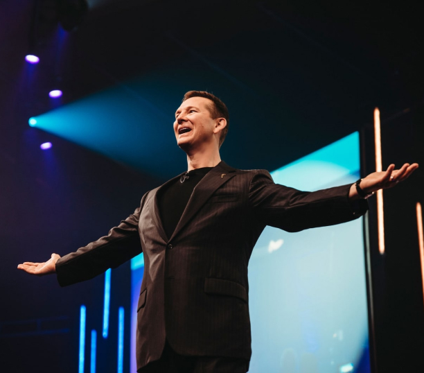 a man with arms open giving a speech